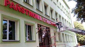 Strażacy mocowali napis na Komendzie 