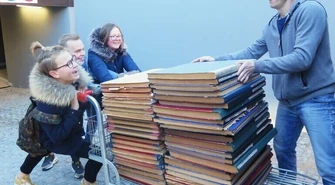 Trwa przeprowadzka biblioteki. Harcerze pomagają przenosić księgozbiór